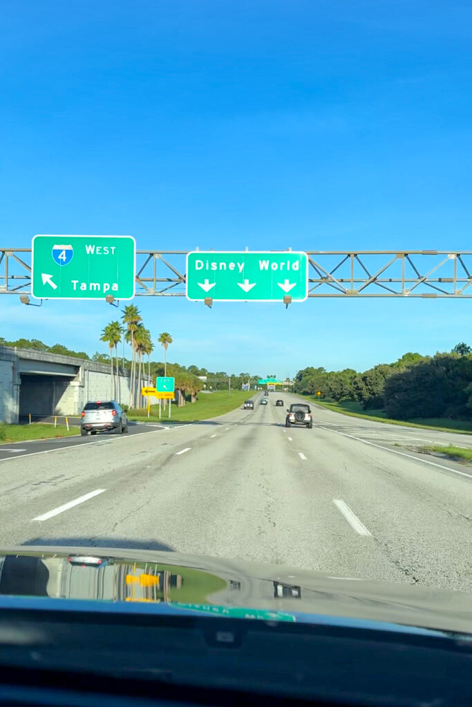 A street sign on the freeway indicating "Disney World"