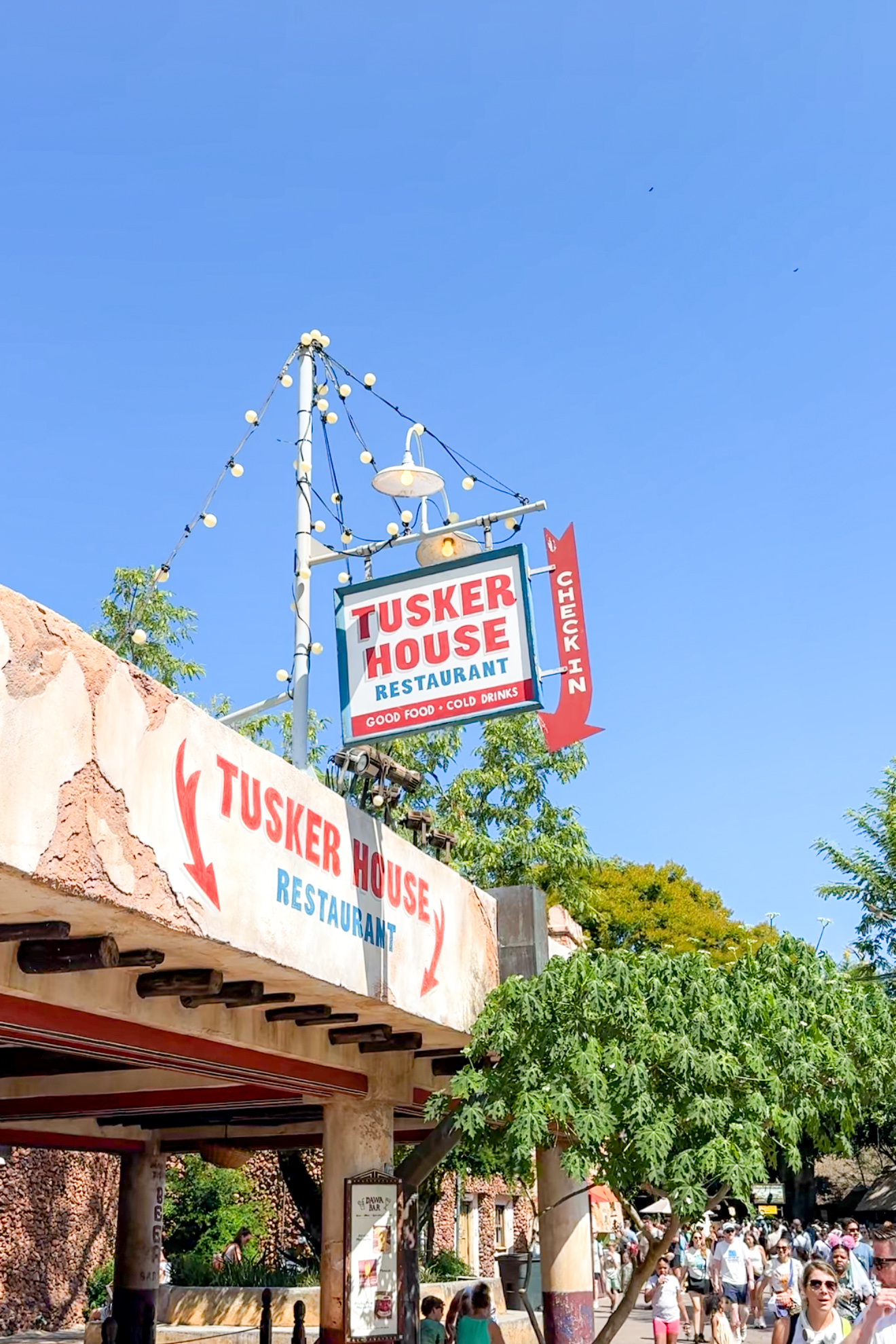 Exterior of Tusker House restaurant at Disney’s Animal Kingdom with entrance sign and colorful awning.