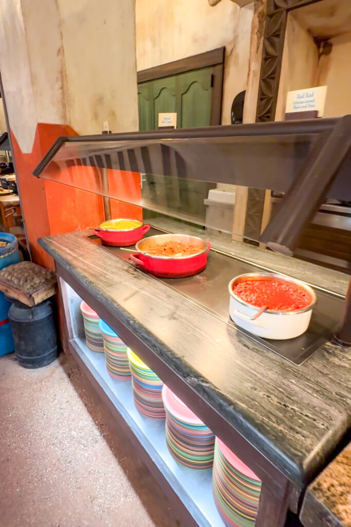 Buffet area inside Tusker House with food trays and serving utensils.