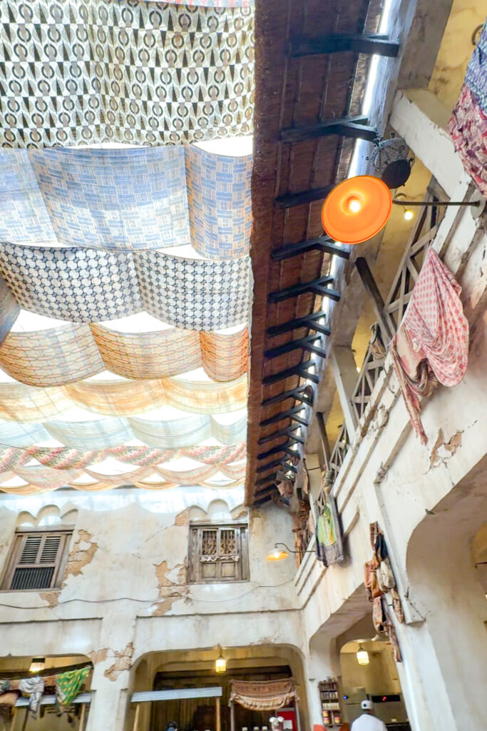 Interior view of Tusker House restaurant, showing décor, seating, and hanging lanterns.